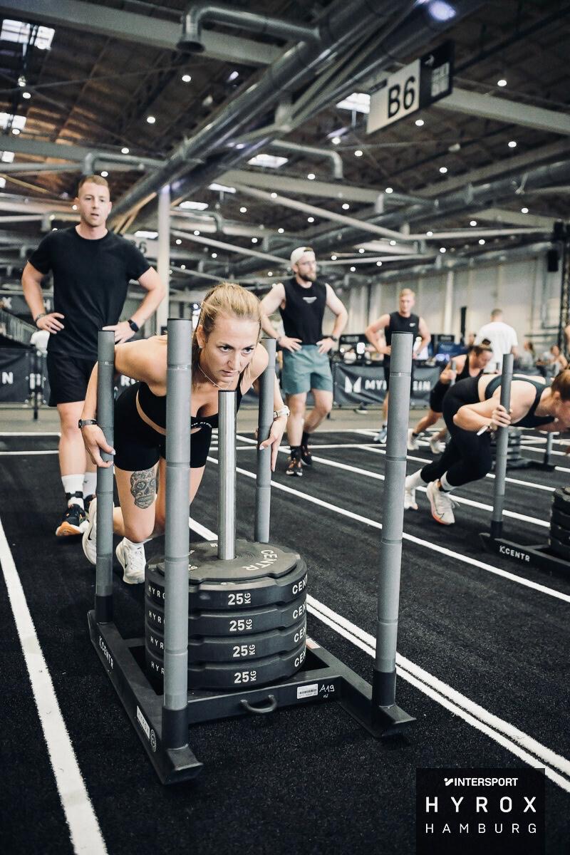 TEAM-HYBRID-Athletin beim Sled Push in der Hamburg Messe beim HYROX Hamburg 2025