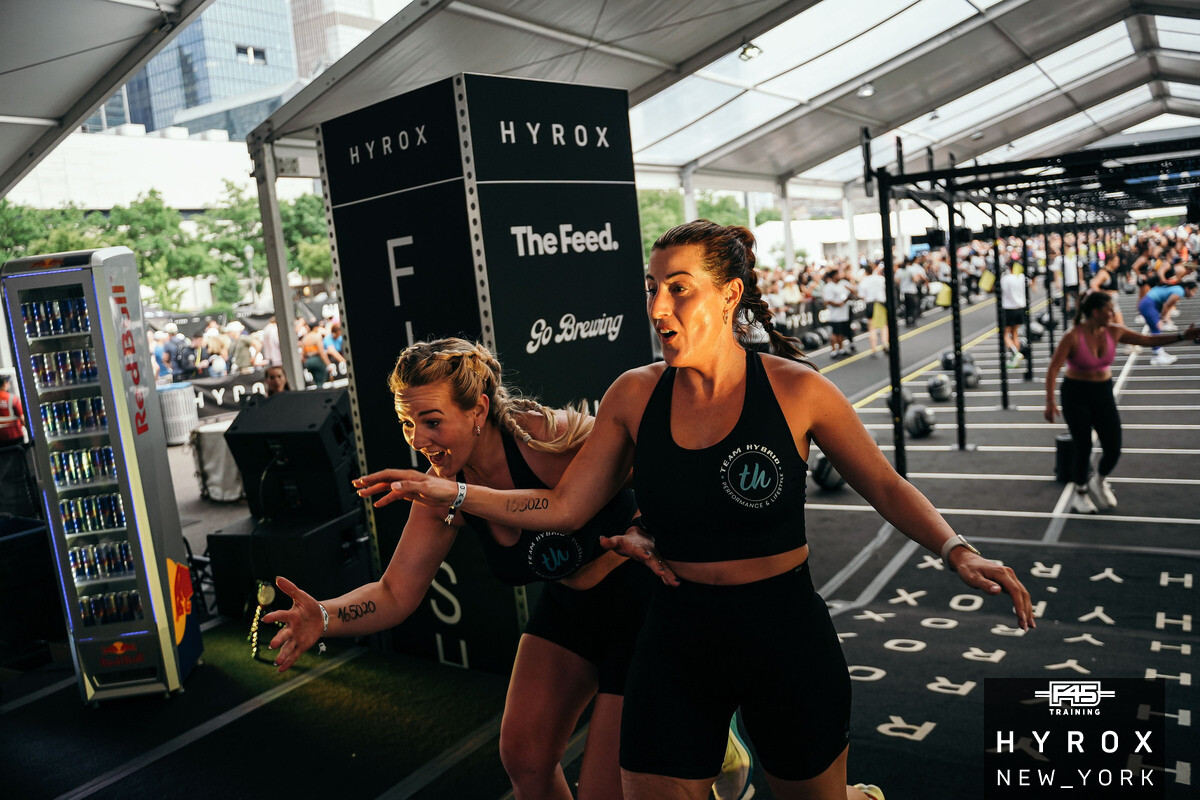 Zwei TEAM-HYBRID-Athletinnen auf der Wettkampffläche beim HYROX New York 2025 am Pier 76