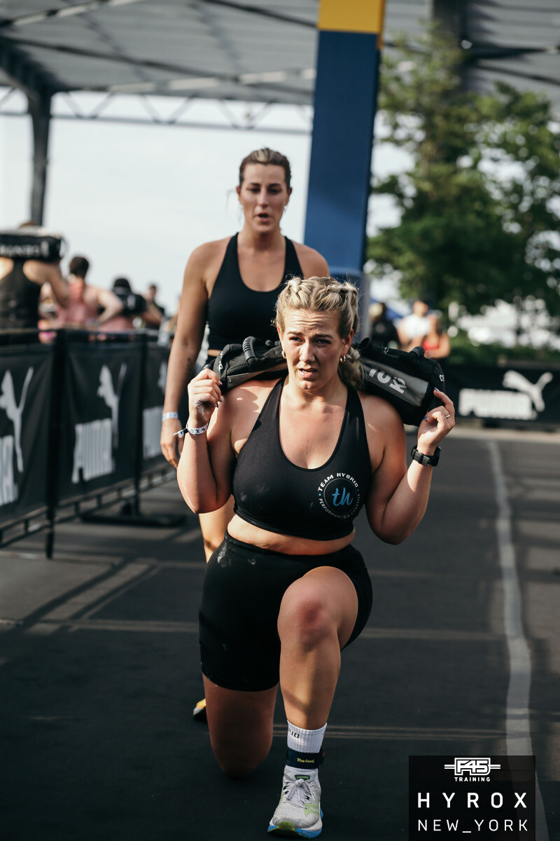 TEAM-HYBRID-Athletin bei den Sandbag Lunges beim HYROX New York 2025 am Pier 76