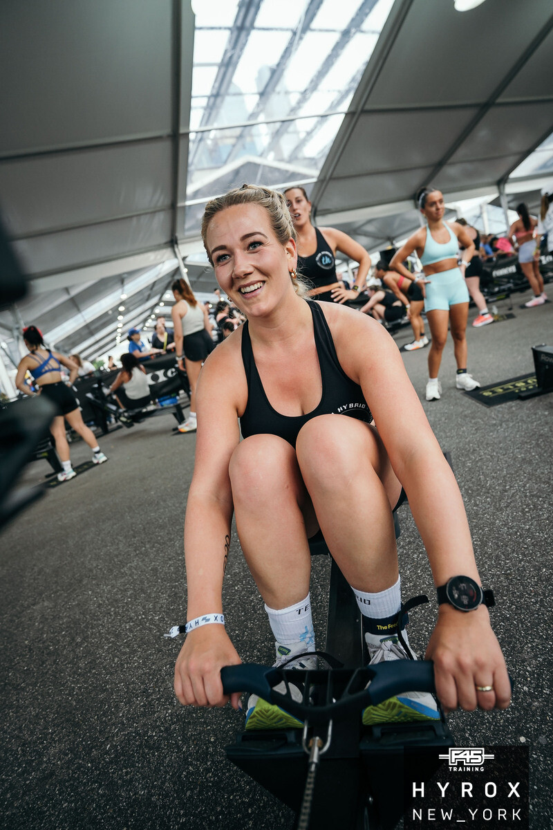 TEAM-HYBRID-Athletin auf dem Bike beim HYROX New York 2025 am Pier 76