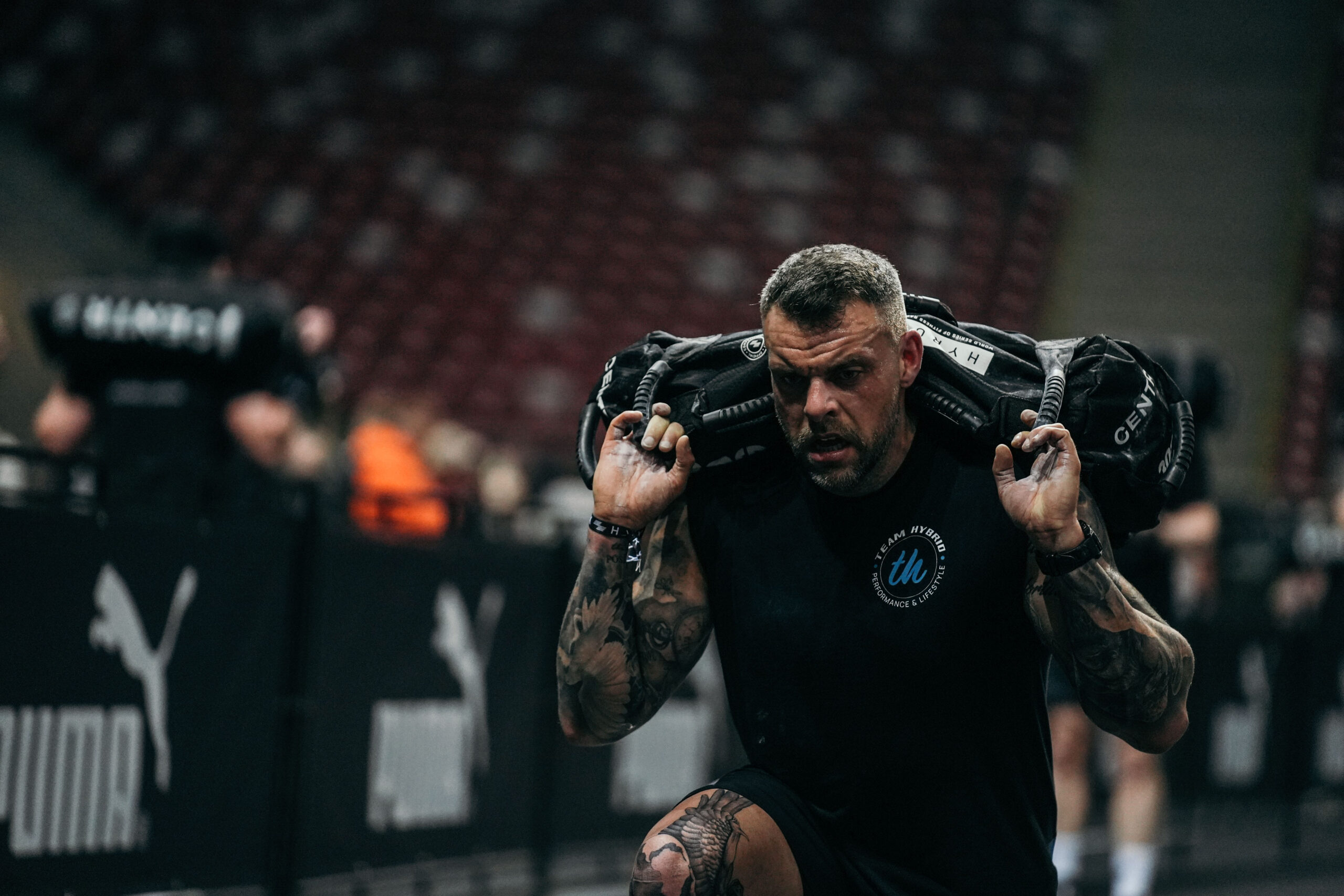 Torge Hannemann von TEAM HYBRID mit Sandbag auf den Schultern beim HYROX Warschau 2025 im PGE Narodowy